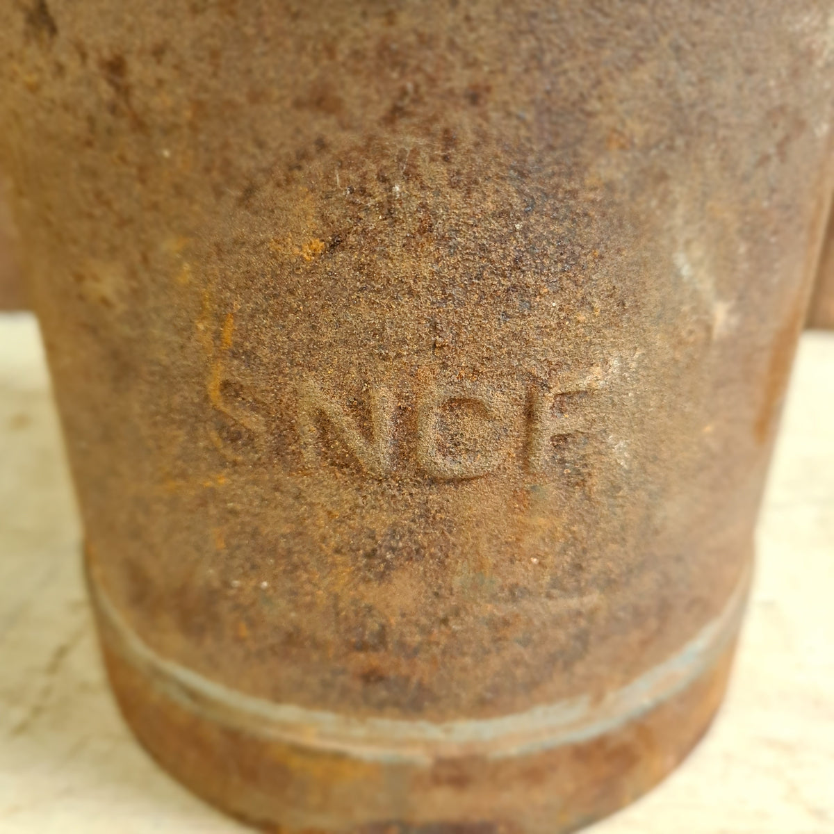 Oude petroleumkan – SNCF, roestige gietijzeren pijpkoppeling met reliëfstempel.