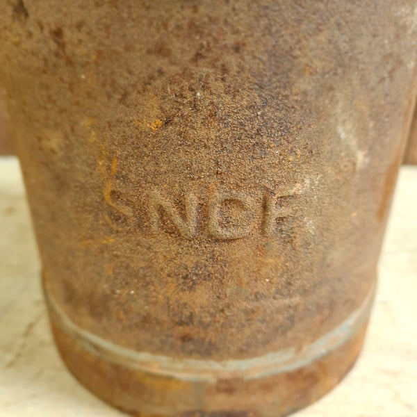 Oude petroleumkan – SNCF, roestige gietijzeren pijpkoppeling met reliëfstempel.