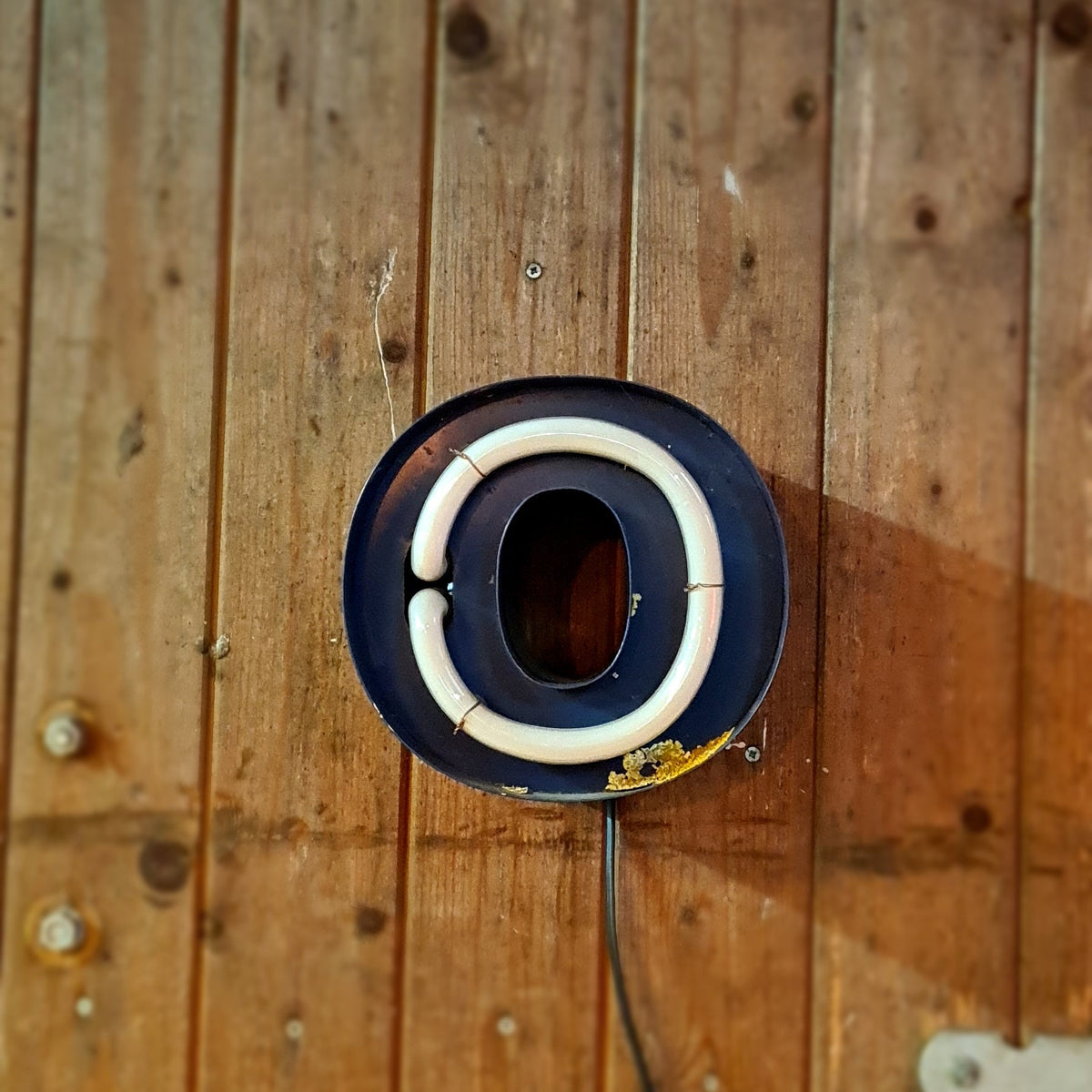 Klein formaat neonletter in blauw, industriële verlichting met patina en roest - Heavy Stuff.