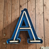 Industriële verlichting: N neon letter blauw/wit op houten wand, patina - Heavy Stuff.