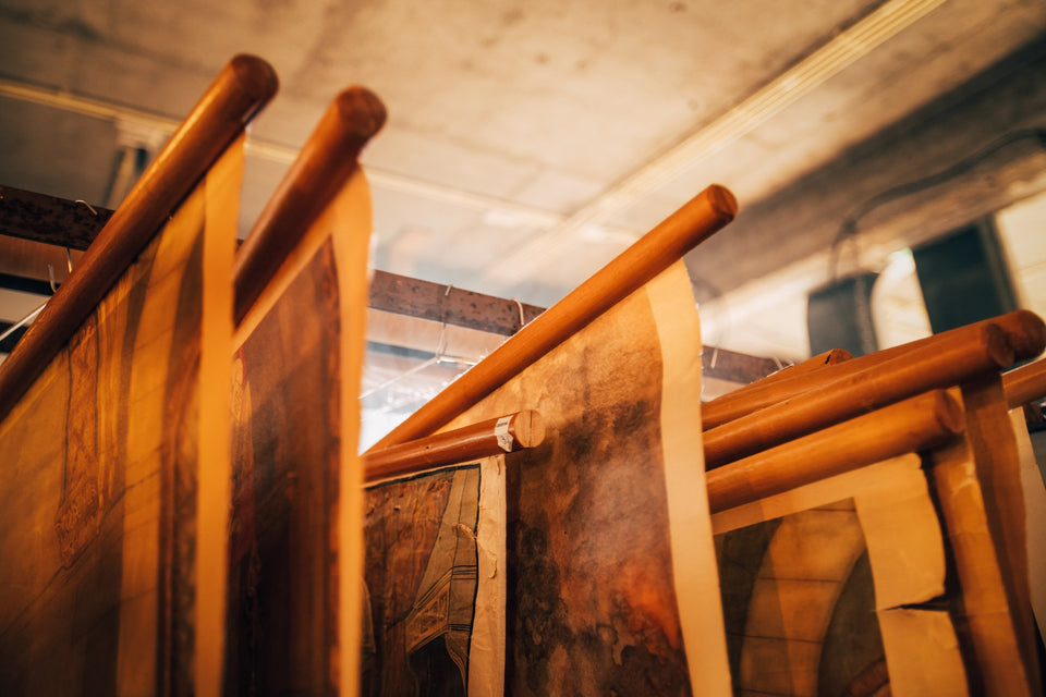 Detail van oude linnen schoolplaten - Heavy Stuff - Close-up van de bedrukking, lichte verkleuringen en de robuuste houten ophangstokken van originele wandkaarten.