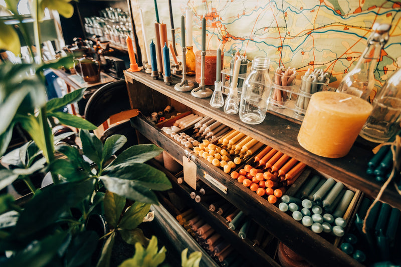 alt="Zware glazen kaarsenhouders en dik vintage glaswerk, robuuste industriële decoratie voor een stoer interieur