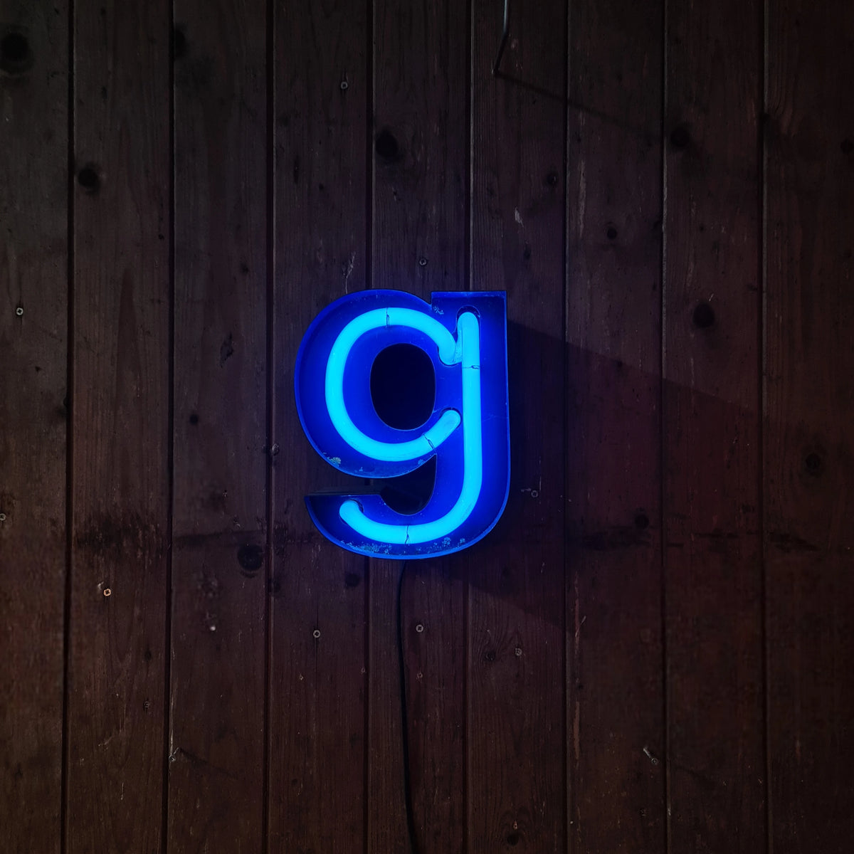 Klein formaat neonletter in blauw, industriële verlichting met patina en roest - Heavy Stuff.