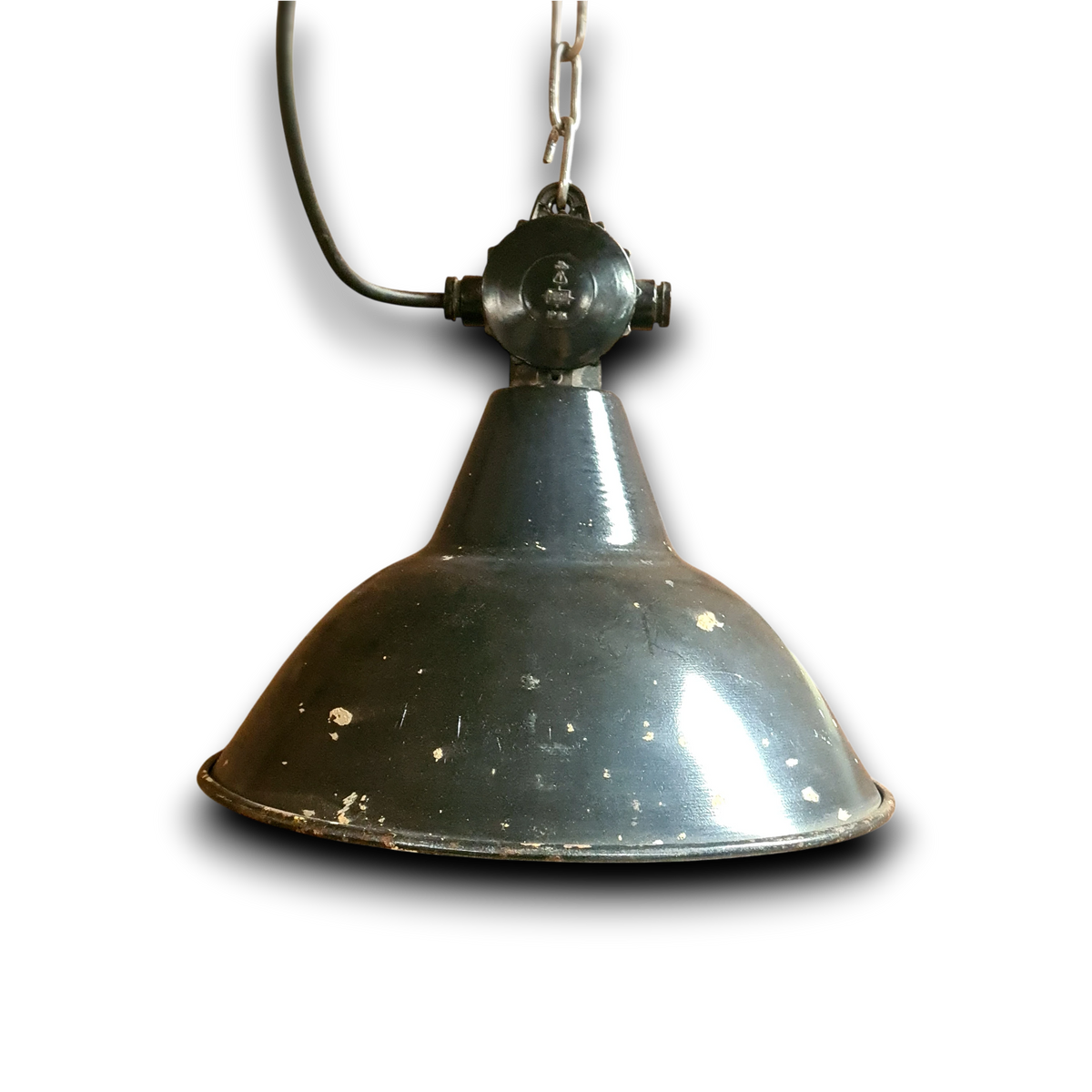 Close-up van de zware gietijzeren kop, ophangketting en nieuwe veilige bedrading van een originele industriële fabriekslamp.