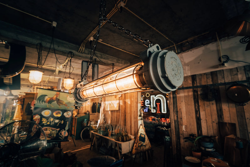 Grote vintage fabriekslamp hangend aan zware kettingen voor een industrieel interieur.